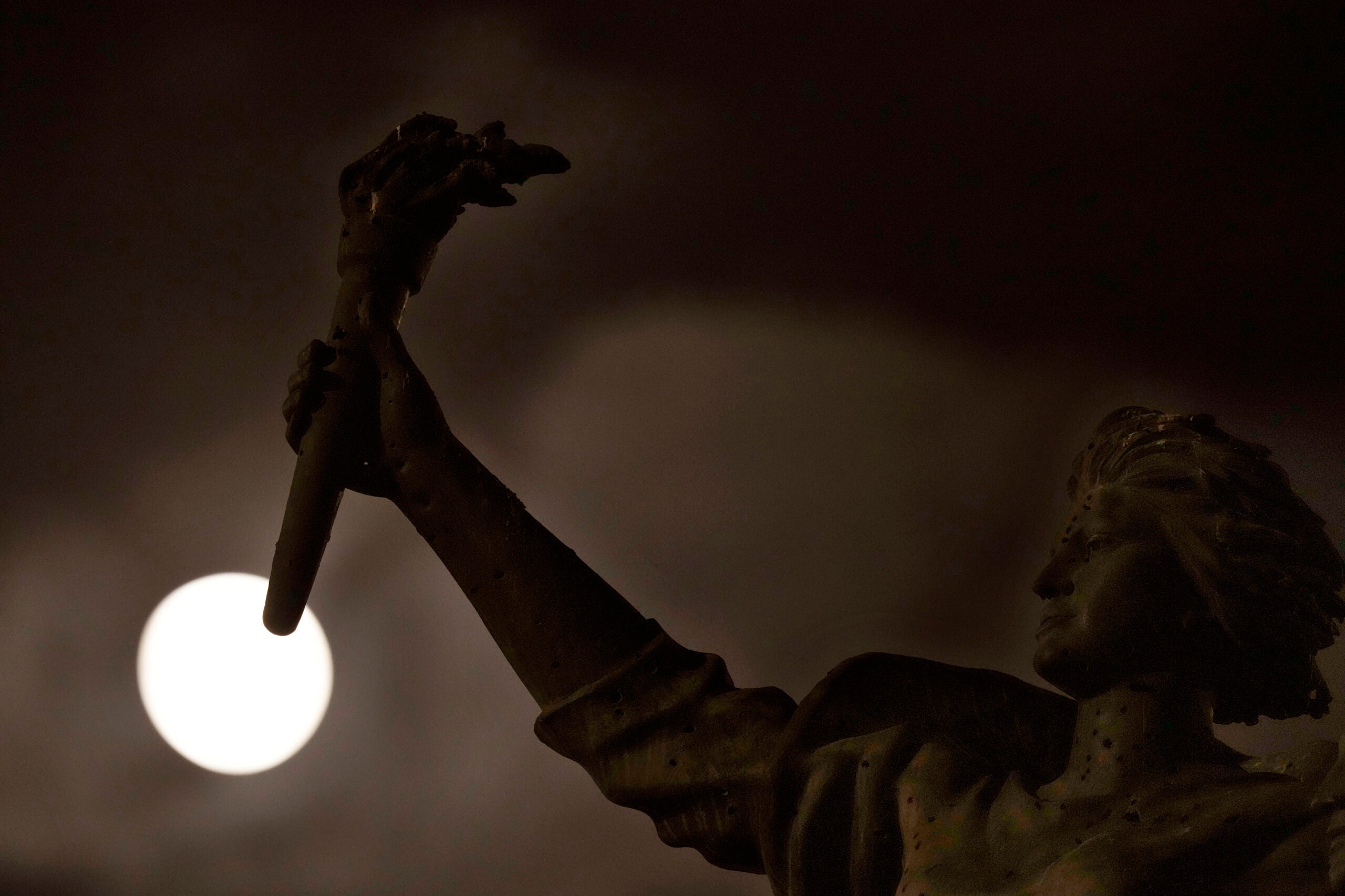 The full moon rises beyond the Martyrs statue, in downtown Beirut, Lebanon.