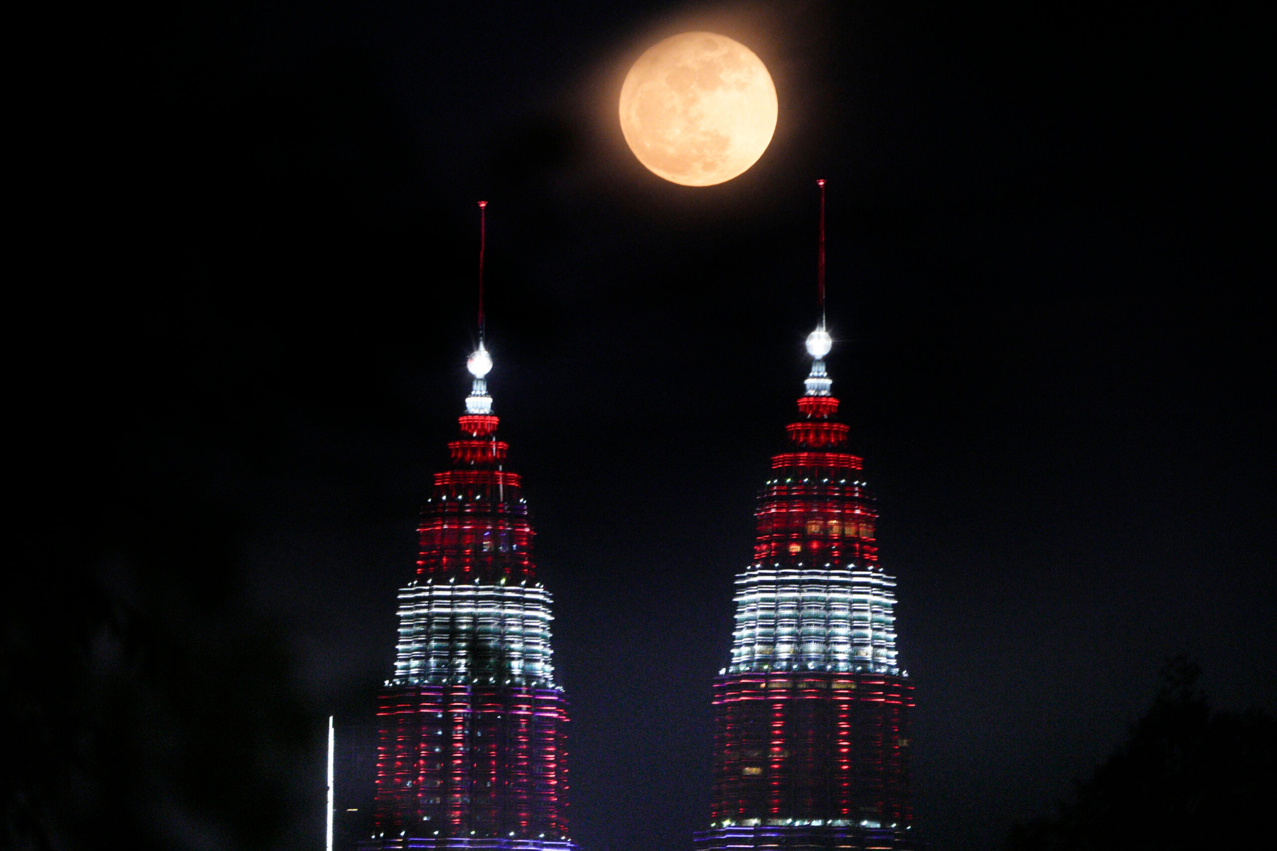 A supermoon rises over Petronas Twin Towers in Kuala Lumpur, Malaysia.