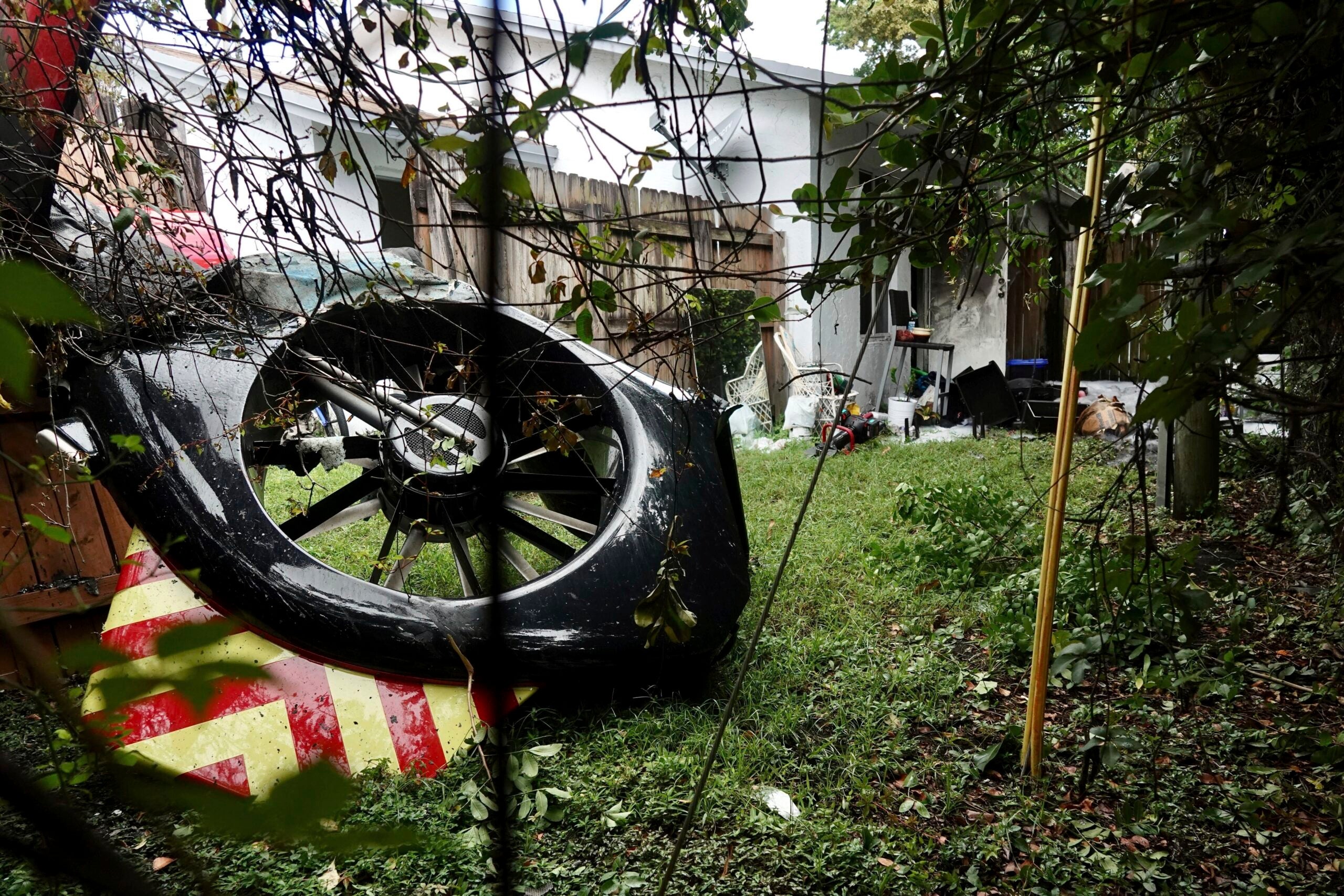 The tail rotor of a Broward Sheriff's Office Fire-Rescue helicopter is seen in the backyard of a home after crashing on Monday, Aug. 28, 2023, near Fort Lauderdale. Fla. (Joe Cavaretta/South Florida Sun-Sentinel via AP)