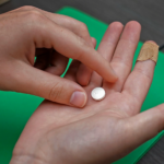 A mifepristone pill sits in someone's open palm.