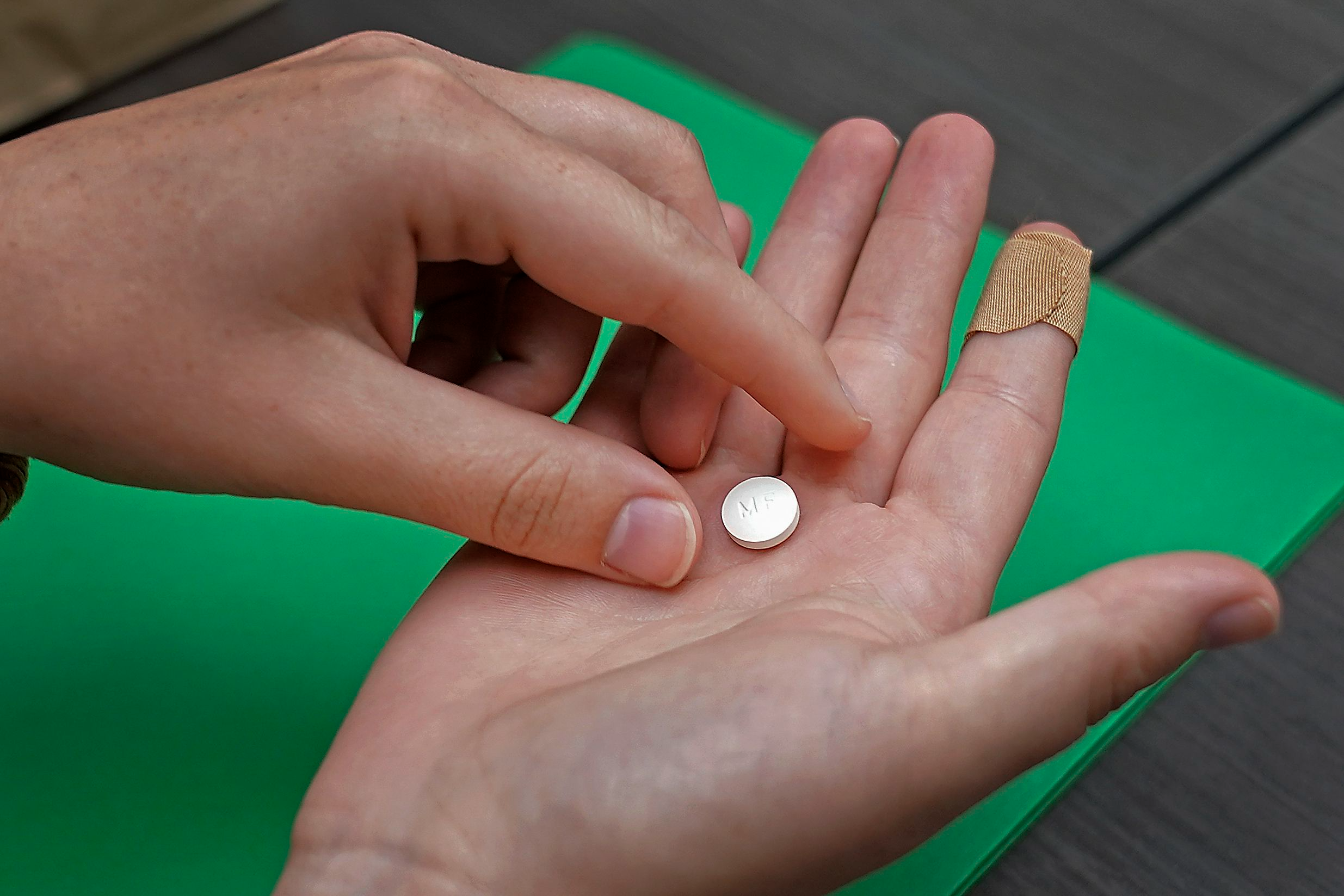 A mifepristone pill sits in someone's open palm.