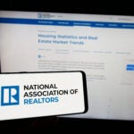 The NAR, or National Association of Realtors, logo on a phone before a computer screen.