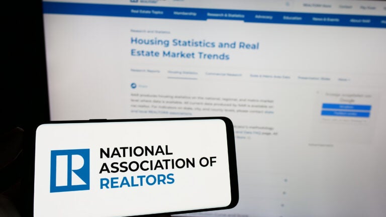 The NAR, or National Association of Realtors, logo on a phone before a computer screen.