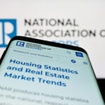 NAR National Association of Realtors Stuttgart, Germany - 03-17-2023: Mobile phone with webpage of US National Association of Realtors (NAR) on screen in front of business logo. Focus on top-left of phone display.