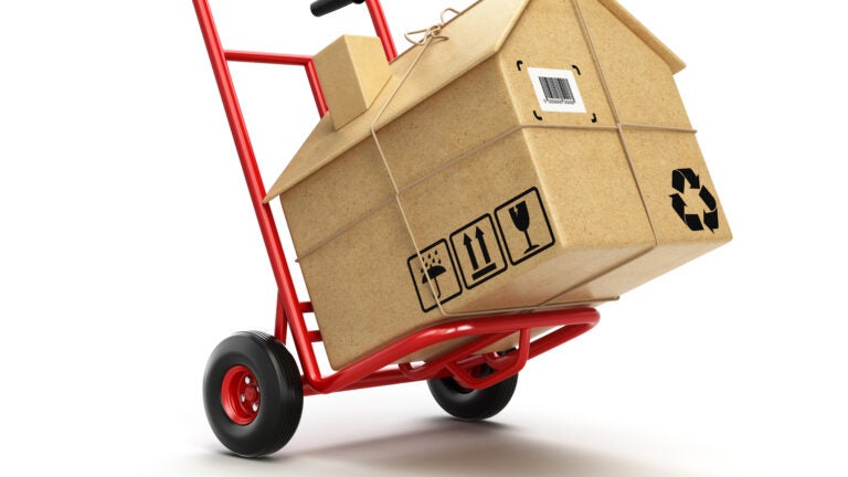 Delivery or moving houseconcept. Hand truck with cardboard box as home isolated on white. 3d millennials
