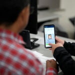 An officer helps set up a phone.
