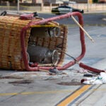 FILE - The basket of a hot air balloon lies on the pavement after a crash landing in Albuquerque, N.M., Saturday, June 26, 2021.