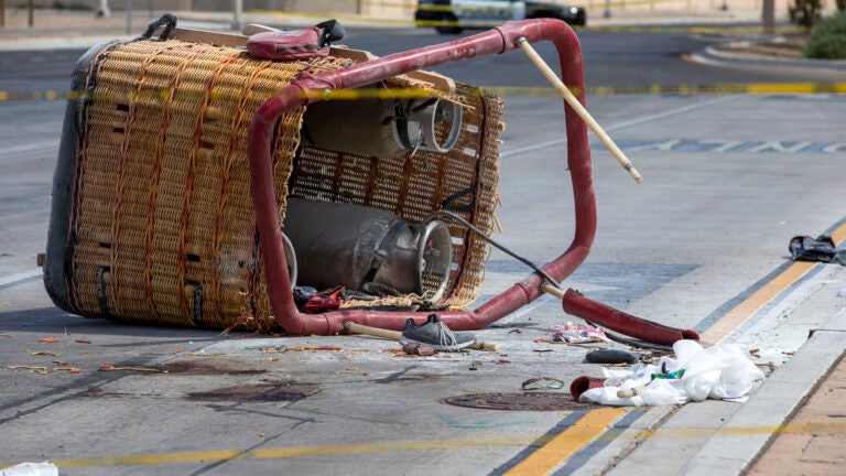 FILE - The basket of a hot air balloon lies on the pavement after a crash landing in Albuquerque, N.M., Saturday, June 26, 2021.
