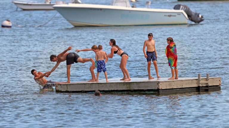 A helping hand was used to pull a boy off the floating dock in Waquoit Bay in Falmouth for a quick splash.