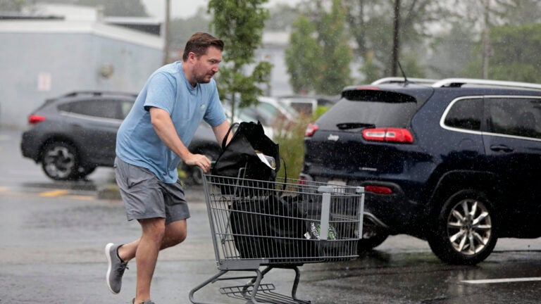 After shopping at the Fruit Center Marketplace (cq), in Milton, this man rushes to his truck, in a downpour.