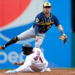 Milwaukee Brewers second baseman Luis Urias (2) forces out Cleveland Guardians' Amed Rosario (1) at second and throws out Jose Ramirez at first base to complete the double play during the first inning of a baseball game, Friday, June 23, 2023, in Cleveland.