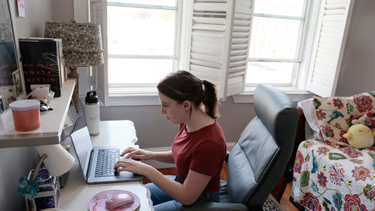 Hayley Kalukin, 22, a web designer for Boston Medical Center works from her home office inside her bedroom.