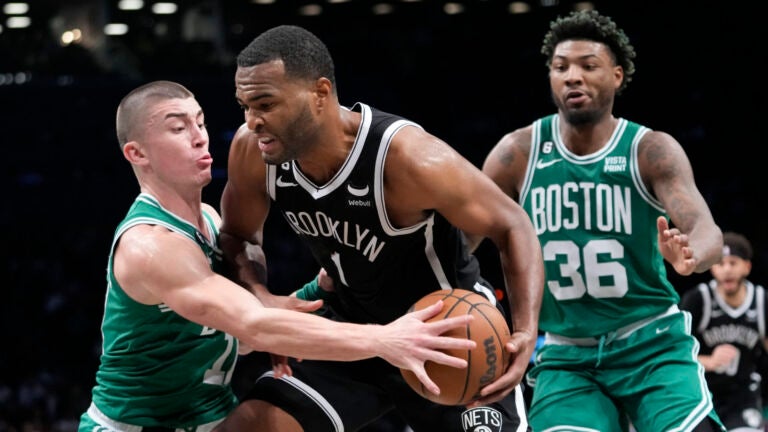 Brooklyn Nets forward T.J. Warren (1) drives against Boston Celtics guard Payton Pritchard, left, and guard Marcus Smart (36) during the second half of an NBA basketball game, Thursday, Jan. 12, 2023, in New York. The Celtics won 109-98.