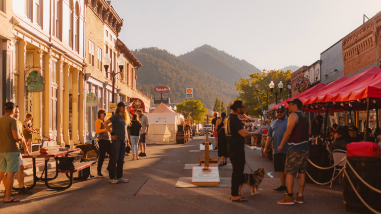 A bustling pedestrian street with mountains in the distance