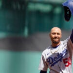 Los Angeles Dodgers' Mookie Betts waves his helmet as he receives applause from the crowd before his first at bat in the first inning of a baseball game against the Boston Red Sox, Sunday, Aug. 27, 2023, in Boston.