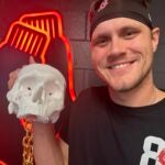 Tanner Houck holds up a necklace with a model of his skull on it.
