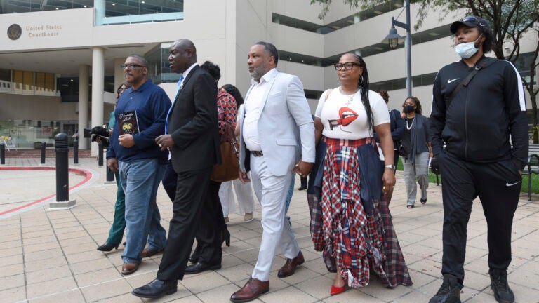 Attorney Ben Crump, second from left, walks with Ron Lacks, left, Alfred Lacks Carter, third from left, both grandsons of Henrietta Lacks, and other descendants of Lacks, outside the federal courthouse in Baltimore, Oct. 4, 2021.