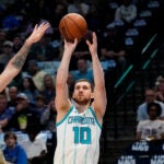 Charlotte Hornets guard Svi Mykhailiuk (10) shoots against Dallas Mavericks guard Luka Doncic (77) during the first quarter of an NBA basketball game in Dallas, Friday, March 24, 2023.