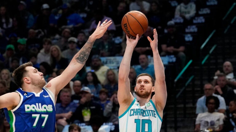 Charlotte Hornets guard Svi Mykhailiuk (10) shoots against Dallas Mavericks guard Luka Doncic (77) during the first quarter of an NBA basketball game in Dallas, Friday, March 24, 2023.