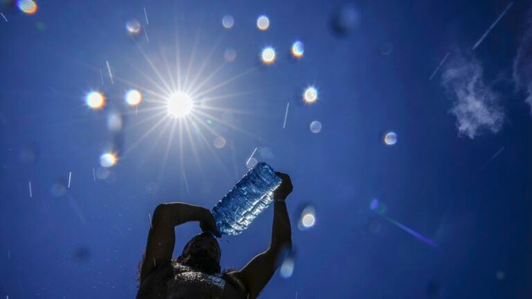 A man pours cold water onto his head to cool off.