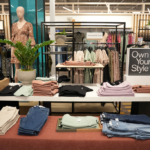The interior of a clothing store, with a display of folded women's clothing