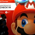 FILE - A person passes an ad featuring the Nintendo character Mario at Narita airport in Narita near Tokyo.