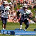 New England Patriots running back J.J. Taylor (42) performs field drills in front of running back Pierre Strong Jr. (35) during an NFL football practice, Wednesday, Aug. 2, 2023, in Foxborough, Mass.