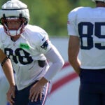 New England Patriots tight end Mike Gesicki (88), left, warms up in front of tight end Hunter Henry (85) during an NFL football practice, Wednesday, Aug. 2, 2023, in Foxborough, Mass.