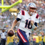 New England Patriots quarterback Mac Jones (10) reacts after a touchdown during the first half of a preseason NFL football game against the Green Bay Packers Saturday, Aug. 19, 2023, in Green Bay, Wis.