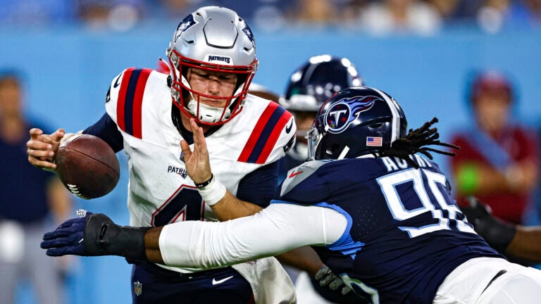 New England Patriots quarterback Bailey Zappe (4) has the ball stripped by Tennessee Titans defensive end Denico Autry (96) during their NFL football game Friday, Aug. 25, 2023, in Nashville, Tenn.