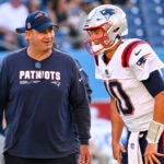 New England Patriots offensive coordinator quarterbacks Bill O'Brien stands near quarterback Mac Jones (10) before an NFL preseason football game against the Tennessee Titans Saturday, Aug. 26, 2023, in Nashville, Tenn.