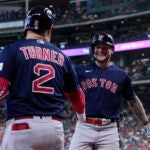 Boston Red Sox's Alex Verdugo celebrates with Justin Turner after hitting a solo home run during the first inning.