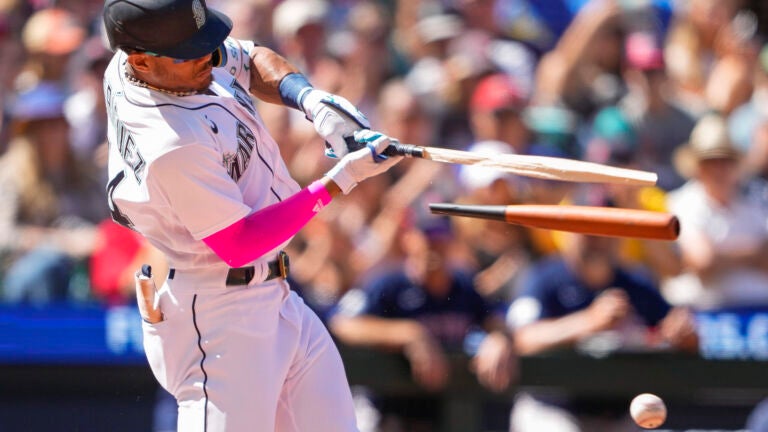 Seattle's Julio Rodriguez breaks his bat on an RBI single during the seventh inning.
