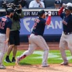 Justin Turner of the Red Sox celebrates with Rafael Devers and Connor Wong after hitting a three-run home run during the seventh inning.
