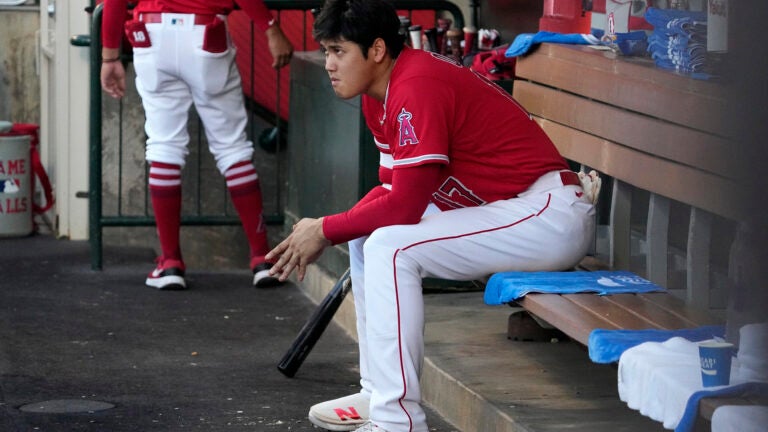 Los Angeles Angels' Shohei Ohtani sits in the dugout.