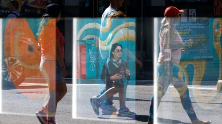 People are seen as they walk through Chinatown in July 2023.