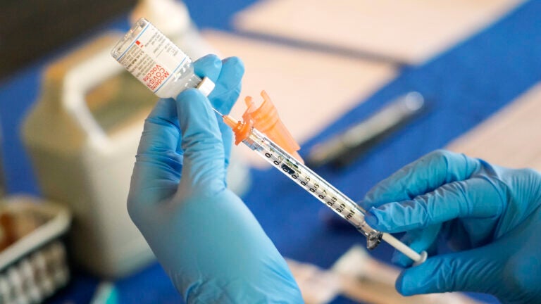 A nurse prepares a syringe for the COVID-19 vaccine at an inoculation station in Jackson, Michigan, on July 19, 2022.