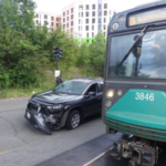 A damaged car next to a trolley.