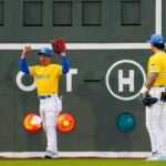 Red Sox left fielder Masataka Yoshida motioned after a ball broke a light on the Green Monster resulting in a ground-rule double for Kansas City's Kyle Isbel during the second inning.
