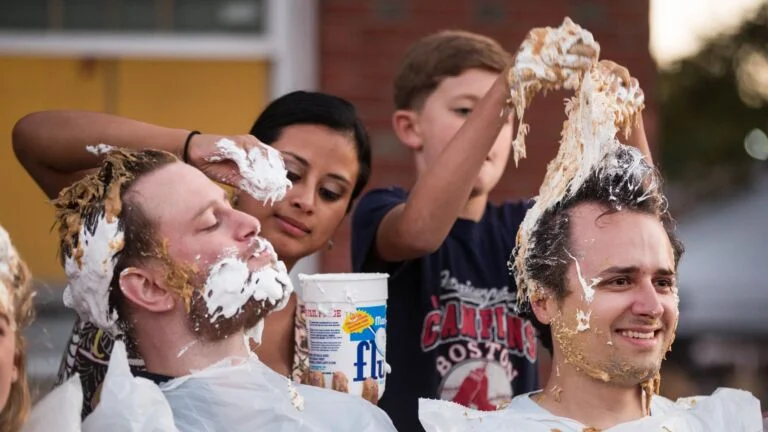 People put Marshmallow Fluff into participants' hair during a What The Fluff? Festival game. 