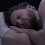 A man struggles to sleep.