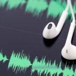 white headphones on top of computer tablet.