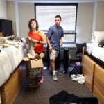 A college student and his mother arrange his room as he moves into a Boston University dorm.