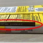 A yellow package of the Nestlé Toll House Chocolate Chip Cookie Dough Bar with a red indicator circling where to look for the date on the back.