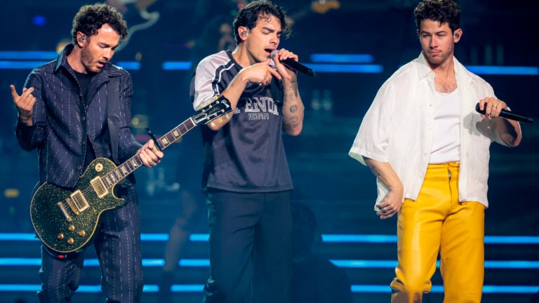 Kevin Jonas, Joe Jonas, and Nick Jonas perform on stage at TD Garden in Boston.