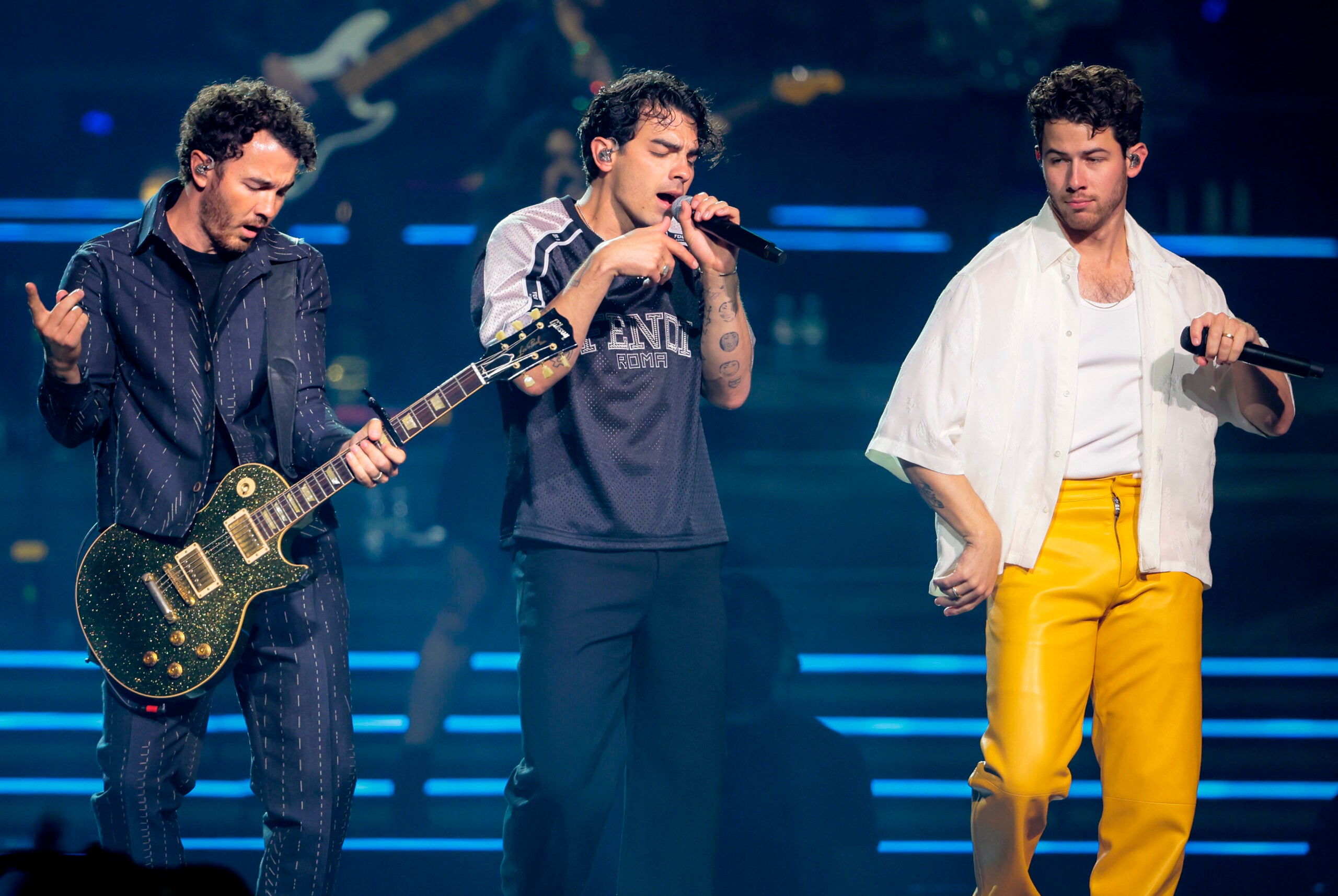 Kevin Jonas, Joe Jonas, and Nick Jonas perform on stage at TD Garden in Boston.