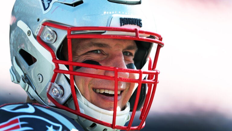 Patriots TE Rob Gronkowski is pictured as he smiles at a friend on the sidelines during pre game warmups.