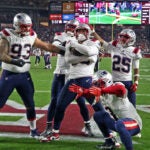 The Patriots Raekwon McMillan (center) and some of his teammates mug it up for the Monday Night Football camera after he returned a third quarter Arizona fumble for a touchdown. The scoreboard behind them is showing the replay of the play and the score reflects the fact that New England had just taken a lead they would not lose. The New England Patriots visited the Arizona Cardinals for an NFL Monday Night Football game at State Farm Stadium.