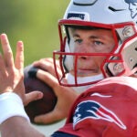 The Patriots held training camp on their practice field at Gillette Stadium.QB Mac Jones fires a pass.