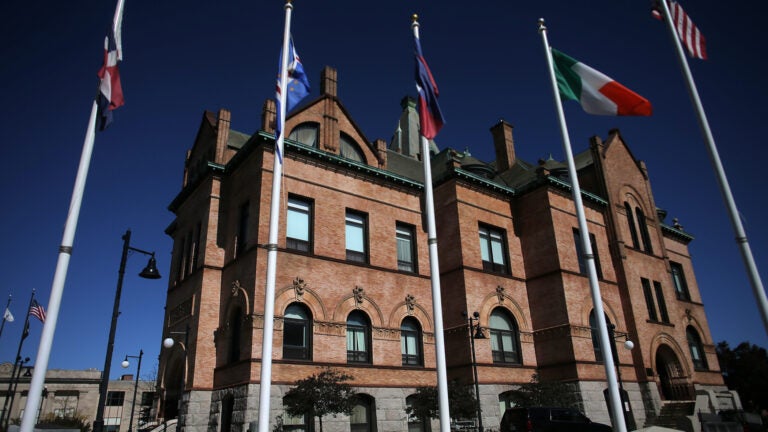 Flags fly in front of Brockton City Hall, a Richardson Romanesque style building.